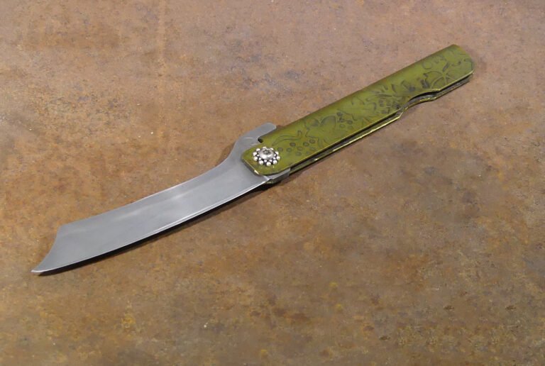 Lame en 14C28N - Manche en laiton gravé et vieilli. Rosette en argent.
